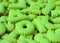 Heap of vibrant lime green alphabet shaped cookies of the letter OK