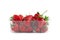 Heap of vivid saturated ripe red strawberries laying in big plastic transparent container and one big berry laying near