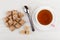 Heap of wafers with filling, teaspoon, sugar cubes and tea