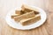 Heap of wafers in white plate on table