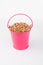 Heap wheat grain in pink bucket on white background