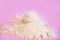 Heap of whey protein powder with plastic spoon on pink background closeup