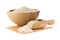 Heap of white uncooked, raw long grain rice in wooden bowl and wooden scoop on white background