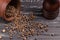 Heap whole organic grains of black pepper on wooden table with p