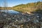 Heaps of construction waste, household waste, foam and plastic bottles on the shore of a forest lake, environmental pollution