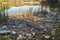 Heaps of construction waste, household waste, foam and plastic bottles on the shore of a forest lake, environmental pollution