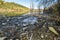 Heaps of construction waste, household waste, foam and plastic bottles on the shore of a forest lake, environmental pollution