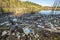 Heaps of construction waste, household waste, foam and plastic bottles on the shore of a forest lake, environmental pollution