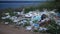 Heaps of plastic trash on the shore of the reservoir. Environmental pollution. Ecology of nature, unorganized garbage dump.