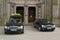 A hearse and a funeral car parked outside a church in ireland