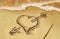 Heart with arrow, as love sign, drawn on the beach shore, with s