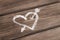 Heart with arrow drawn with chalk on wooden background