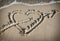 Heart with an arrow drawn on the sand