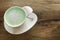heart art shape design on the top of hot japnese green tea matcha milk cup on dark wood table background.