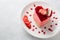 Heart Cake picture . Lovely delicious heart cake. A red colored cheesecake on a plate and a wooden table.