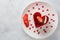 Heart Cake picture . Lovely delicious heart cake. A red colored cheesecake on a plate and a wooden table.