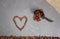 Heart from coffee beans with burlap and spoon at grey kitchen worktop background