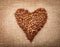 Heart from coffee beans on textured brown sack