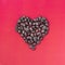 Heart coffee. Roasted coffee beans in the shape of heart on bright red background. Concept of coffee love, Valentine`s Day, good