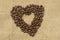 Heart coffee. Roasted coffee beans in the shape of heart on natural canvas, sackcloth. Concept of coffee love or a loved