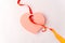 Heart cut out of paper, with tied ribbon in focus in the foreground, white background, symbol of Valentine`s Day