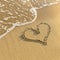 Heart drawn in beach sand, gentle surf wave. Love.