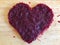 Heart of finely chopped beets on a wooden background