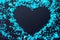 Heart frame of blue confetti - on black background,copy space