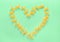 Heart Frame from Wwheat Pasta Farfalle on Green Background. Valentine`s Day or Mother`s Day
