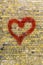 Heart graffiti on a yellow brick wall background