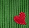 Heart on green knitted wool background