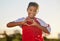 Heart hand and girl portrait at soccer game with passionate and happy sports player in Mexico. Mexican child football