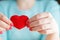 Heart in hands, female holds handmade sewn soft toy