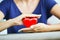 Heart health concept with womanâ€™s hands protecting a shiny red heart