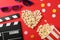 Heart laid out from popcorn, clapperboard, 3d glasses and bucket
