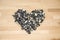 Heart lined with husks of sunflower seeds on a background of beech wood