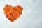 Heart made of apricots on grey background, top view with space for text.