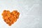 Heart made of apricots on grey background, top view with space for text.