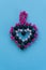 Heart made of beads, children`s crafts on a blue background