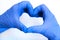 Heart made of blue gloves on a white background. gloved hands