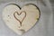 A heart made of a female gold chain on a beautiful, vintage, homemade, wooden heart to Valentine`s Day