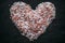 Heart made of Himalayan salt on black slate. Top view. Heart shaped salt as background.