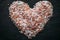 Heart made of Himalayan salt on black slate. Top view. Heart shaped salt as background.