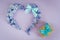 Heart made from hyacinth flowers with mint bow and gift boxes with butterfly on purple background. Greeting card.