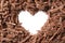 Heart made with milk chocolate crumbles on white background, top view