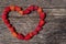 Heart made of ripe aromatic raspberries on a wooden background.