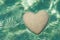 Heart made of sand floating in transparent ocean ripples water b