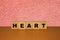 HEART message word on a wooden desk on cube blocks