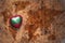 Heart with national flag of maldives on a vintage world map crack paper background.