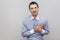 Heart pain or broken heart. Portrait of handsome bristle businessman in classic light blue shirt standing and holding his painful